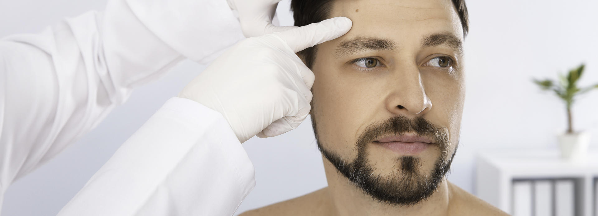 the face of a man with a birthmark being checked by a doctor