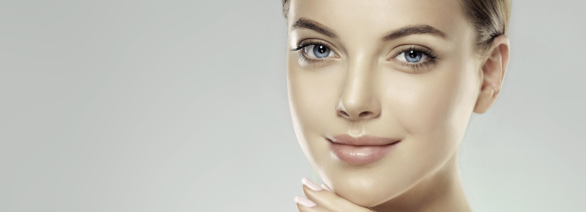 Face of a young-looking woman after cosmetic facial filler treatment.