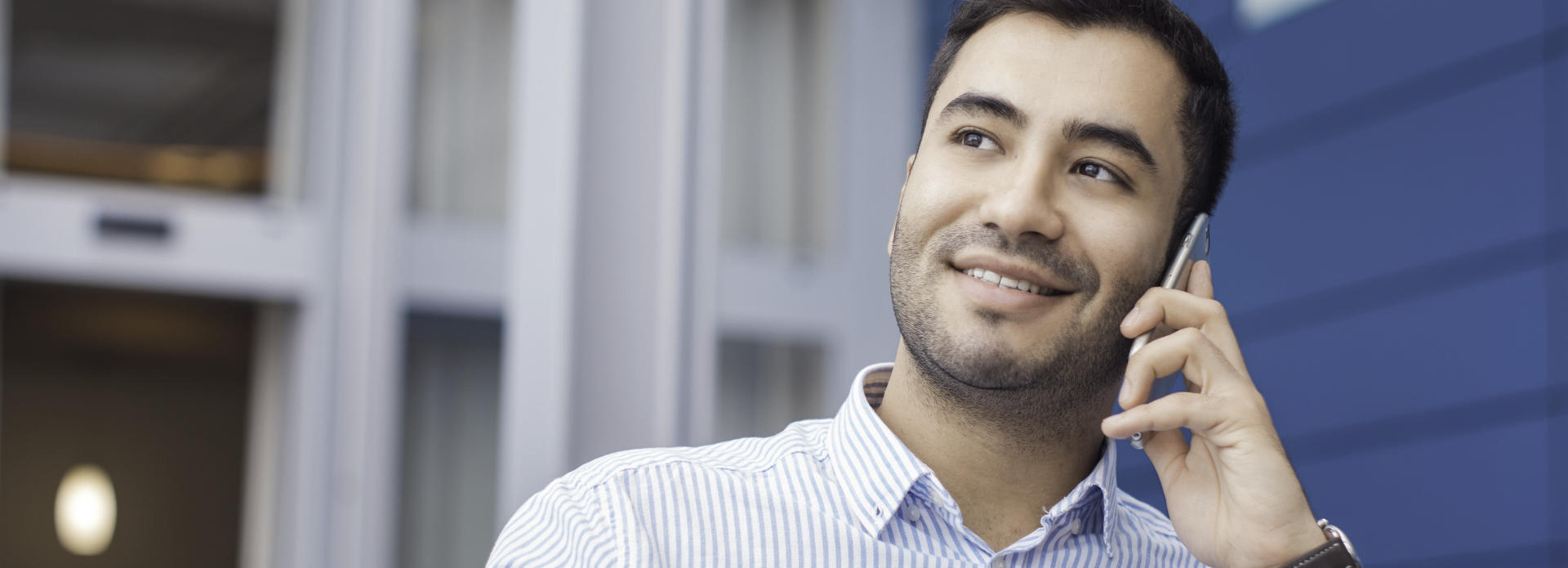 a calm, smiling man talking on his cell phone