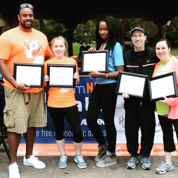 group of people with certificates in frames