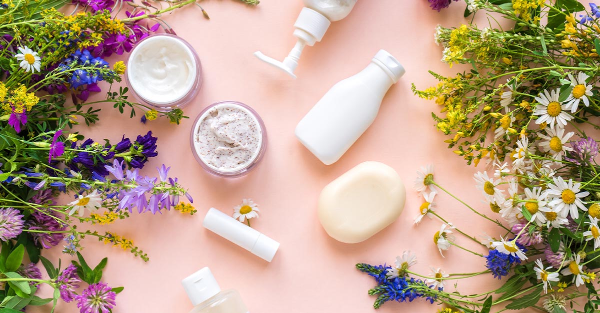 Flat lay photo of skincare products surrounded by wildflowers.