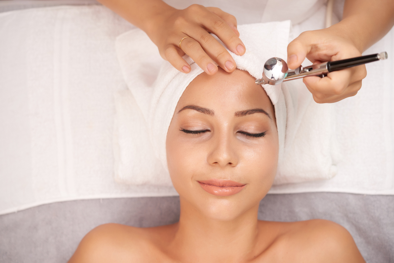 Smiling young woman getting oxygen therapy in beauty salon