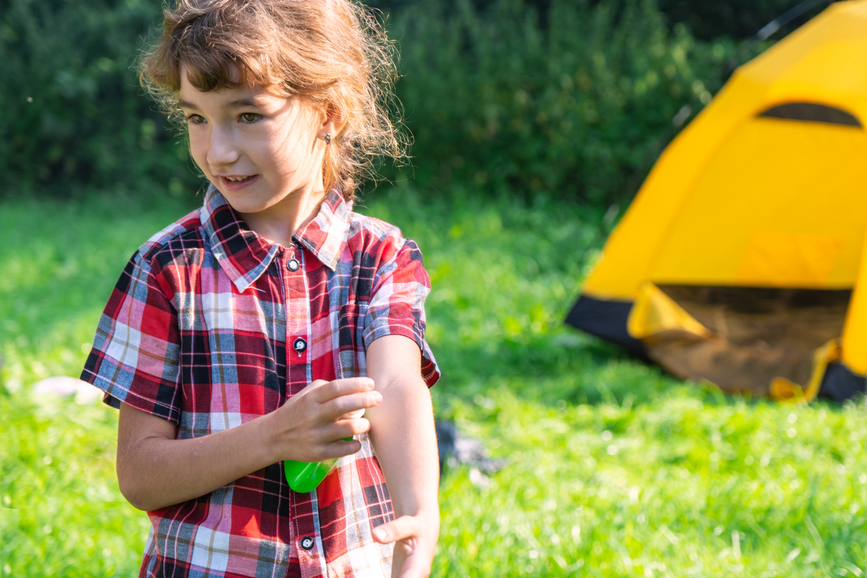 Summer camp skin problems girl with bug bite using spray