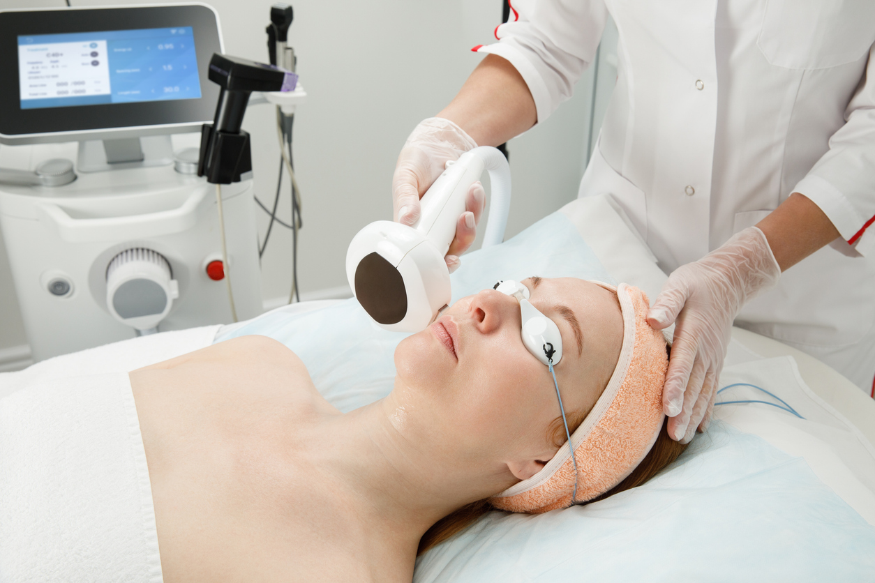 A woman receives laser treatment of the face in a cosmetic dermatology clinic, a concept of skin rejuvenation is being developed. laser peeling.